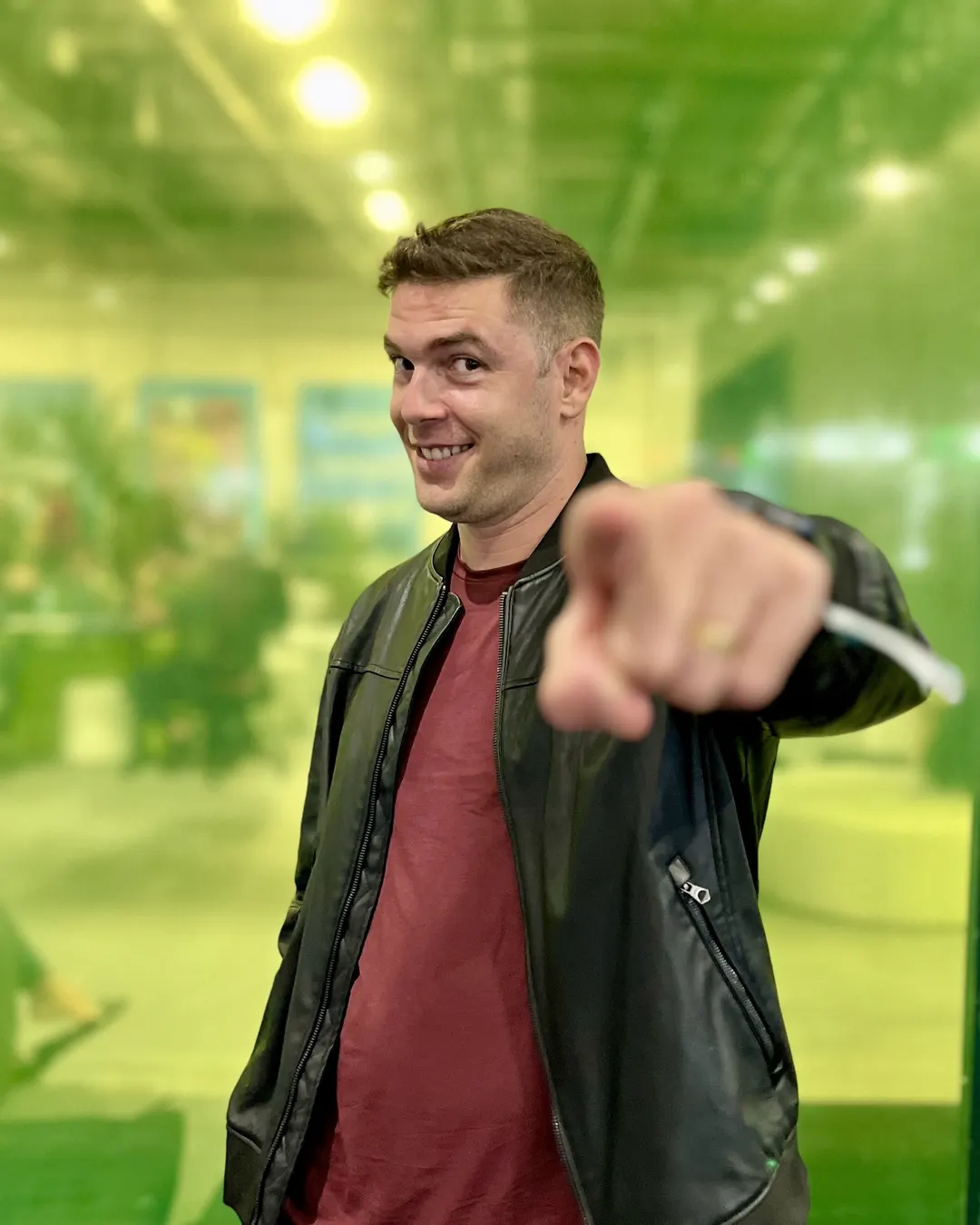 Lucas Neves sorrindo e apontando para a câmera em um evento de tecnologia